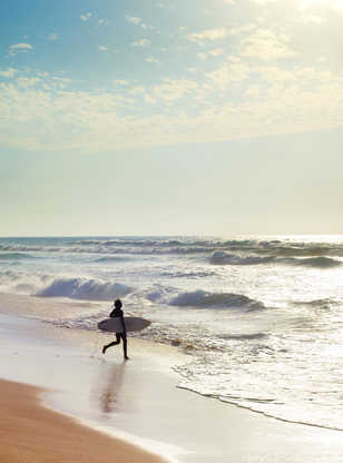 Un surfeur courant sur les plages du Portugal pour aller surfer