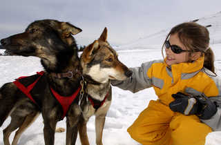 Enfant caressant un Husky dans la neige - © C. MIGEON / ROADBOOKMEDIA Enfant caressant un Husky dans la neige