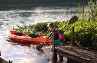 Enfant en bord de lac avec un kayak