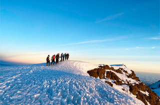 Groupe de randonneurs au sommet du Kilimandjaro enneigé en Tanzanie