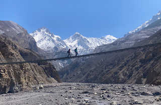 Randonneurs traversant un pont pendant l'ascension de l'Annapurna au Népal