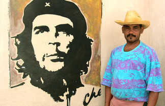 Cubain devant un portrait du Ché dans une rue de la Havane à Cuba