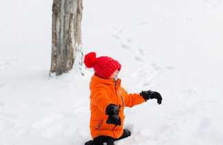 Enfant jouant dans la neige dans le Queyras lors d'une activité famille