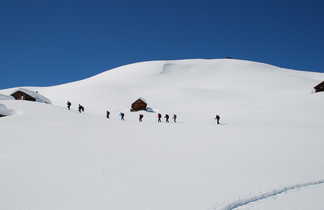 groupe de randonneurs en pleine randonnée entre des chalets au sud est de la France dans les Alpes