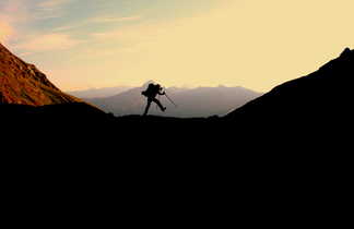 Homme en train de marcher sur les crêtes de la montagne du parc Queyras lors du couché de soleil