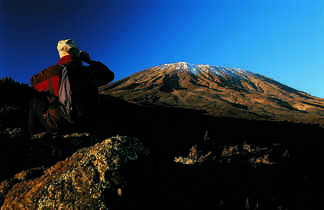 Randonneur avec des jumelles admirant la vue sur le Kilimandjaro en Tanzanie