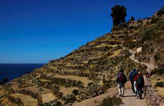 randonneurs au bord du lac Titicaca, au milieu des terrasses incas