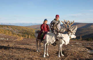 Un homme et son fils et leurs rennes en Mongolie