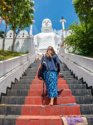 Femme marchant en direction du Grand Bouddha sur le site historique de Kandy