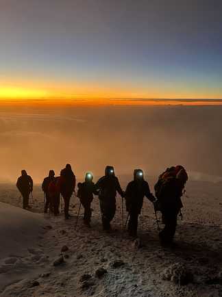 groupe de randonneurs de nuit pendant l'ascension du Kilimandjaro en Tanzanie