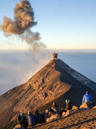 Groupe de randonneurs observant le volcan Fuego fumant depuis le volcan Acatenango au Guatemala