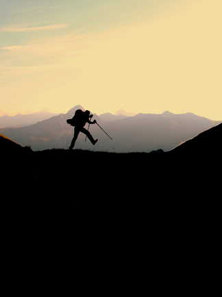 Homme en train de marcher sur les crêtes de la montagne du parc Queyras lors du couché de soleil