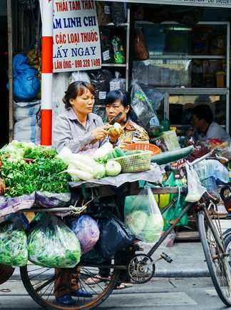 Marchande ambulante à vélo de légumes à Hanoï au Vietnam