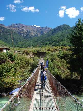 Randonneurs sur un pont suspendu au Bhoutan