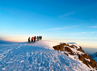Groupe de randonneurs au sommet du Kilimandjaro enneigé en Tanzanie