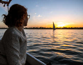 Voyageuse regardant le coucher de soleil sur le Nil