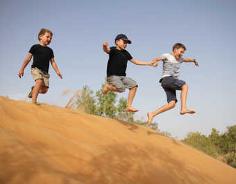Enfants sautant dans les dunes au Sénégal