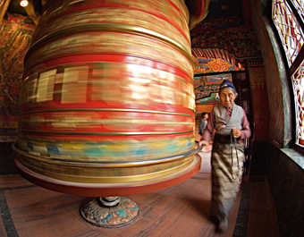 femme népalaise qui fait tourner une roue de prière au Népal