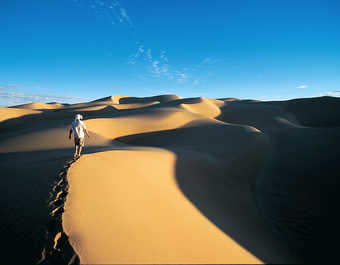 Randonneur dans les dunes au coucher, erg Ouarane, Mauritanie