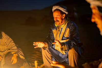 Guide local du Maroc devant un feu dans le désert