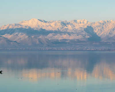 lac Shkodra, reflet des montagnes et un petit bateau de pêche au Monténégro
