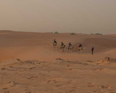 randonneurs en balade a chameaux dans le désert de Lompoul au Sénégal