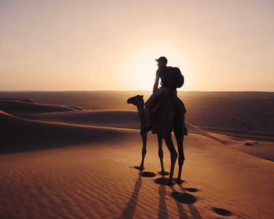 voyageur a dos de chameau dans le désert de Wahiba à Oman