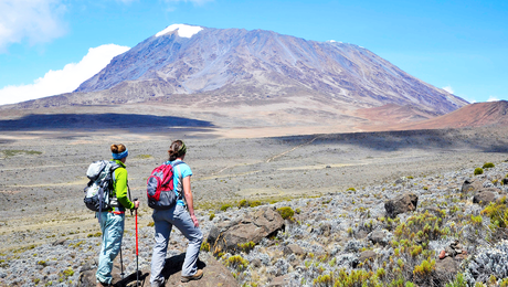 Un couple sur le circuit nord du Kilimandjaro, avec le massif du Kibo en arrière plan, Tanzanie