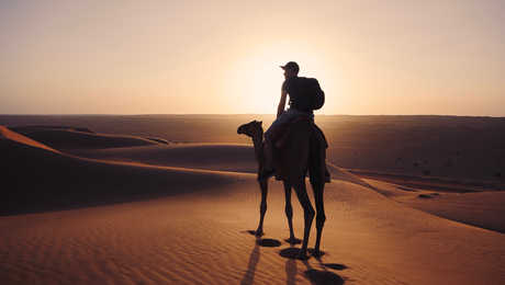 Voyageur à dos de chameau dans le désert de Wahiba à Oman