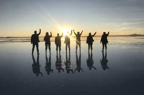 Petit groupe de randonneurs au salar d'uyuni au coucher du soleil