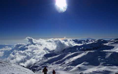Panorama sur les sommets enneigés avec deux alpinistes