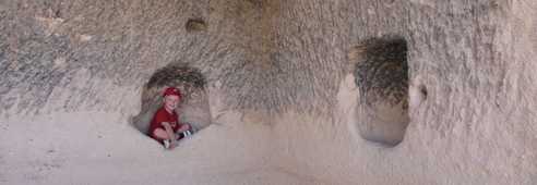 Enfant assis dans la cavité d'une maison troglodyte en Cappadoce