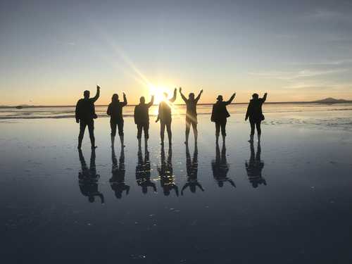 Petit groupe de randonneurs au salar d'uyuni au coucher du soleil