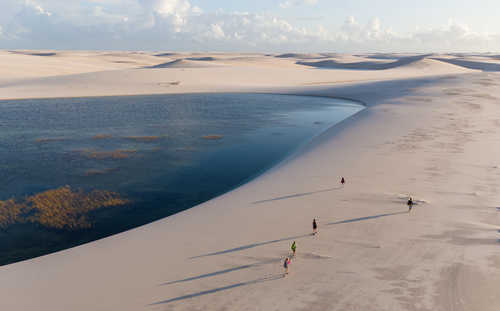 Randonneurs sur une dune au Brésil dans le désert de lençois maranhenses au Brésil