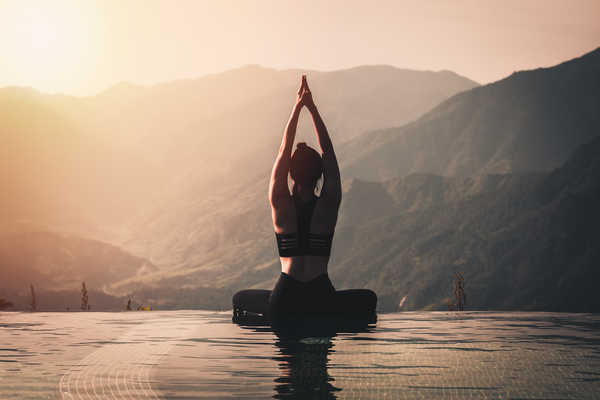 Femme faisant du yoga fasse aux montagnes