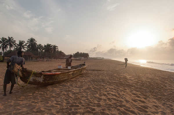 hommes transportant une barques dans le Golf de Guinée, Bénin, Afrique