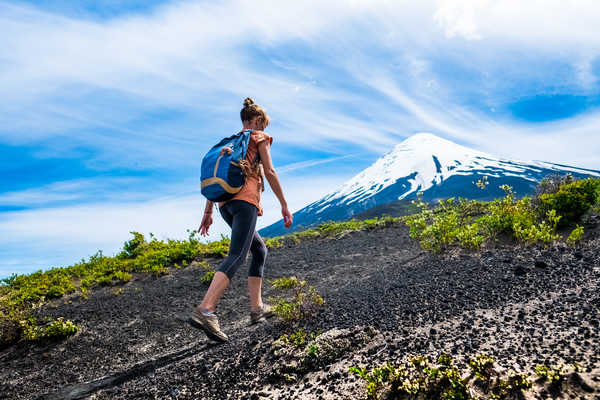 randonneuse qui marche sur le volcan Osorno en face d'un volcan  sur l'ile de Paques