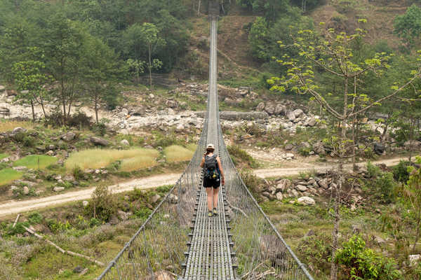 Randonneuse sur un pont au Népal