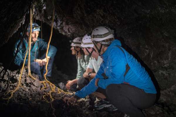 Voyageurs avec un guide dans un tunnel de lave, à la Réunion