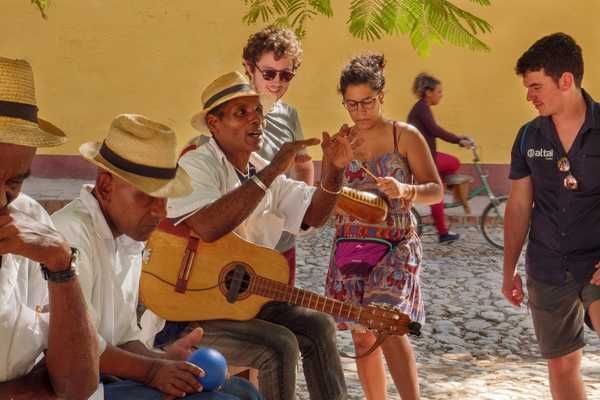 Voyageurs parlant avec des musiciens cubains à Trinidad, à Cuba