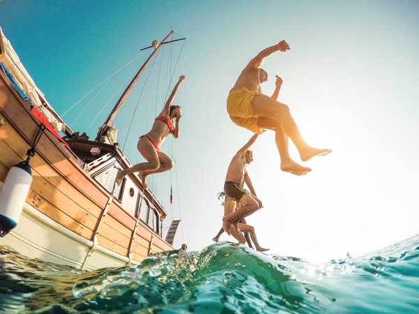 Voyageurs sautant d'un bateau dans la mer