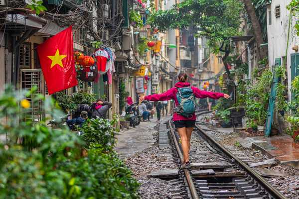 Voyageuse marchant sur les rails d'Hanoï, au Vietnam