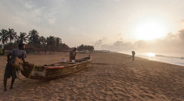 hommes transportant une barques dans le Golf de Guinée, Bénin, Afrique