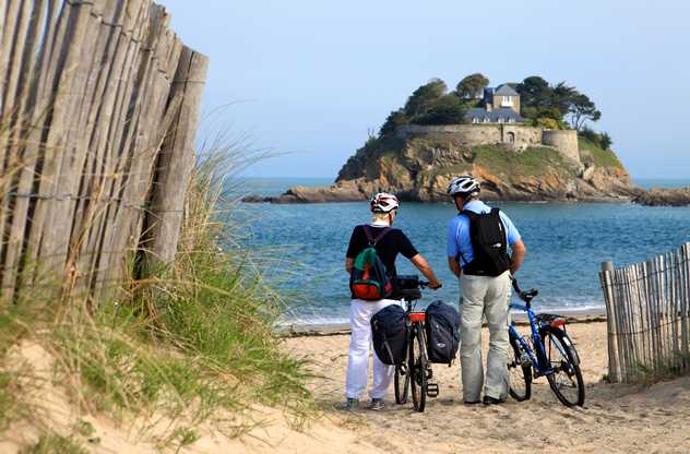 Cyclistes face à la mer sur la côte d'Emeraude en Bretagne