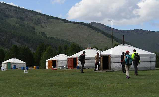 groupe de randonneurs devant leurs yourtes en Mongolie