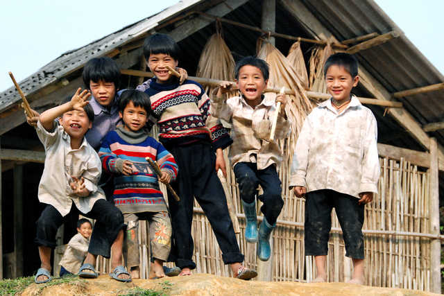 Groupe d'enfants jouant devant une maison traditionnelle au Vietnam