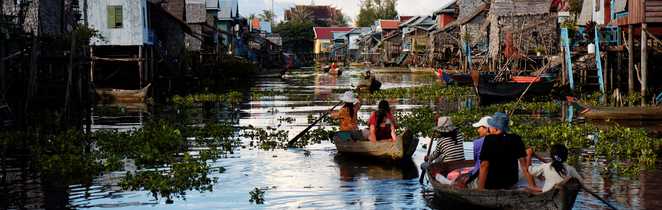 locaux qui traverse un village sur pilotis  Cambodge