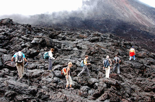 Randonneurs sur le champ de lave d'un volcan Guatemala