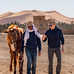 Randonneur avec son guide local qui discutent en marchant avec un âne au Maroc