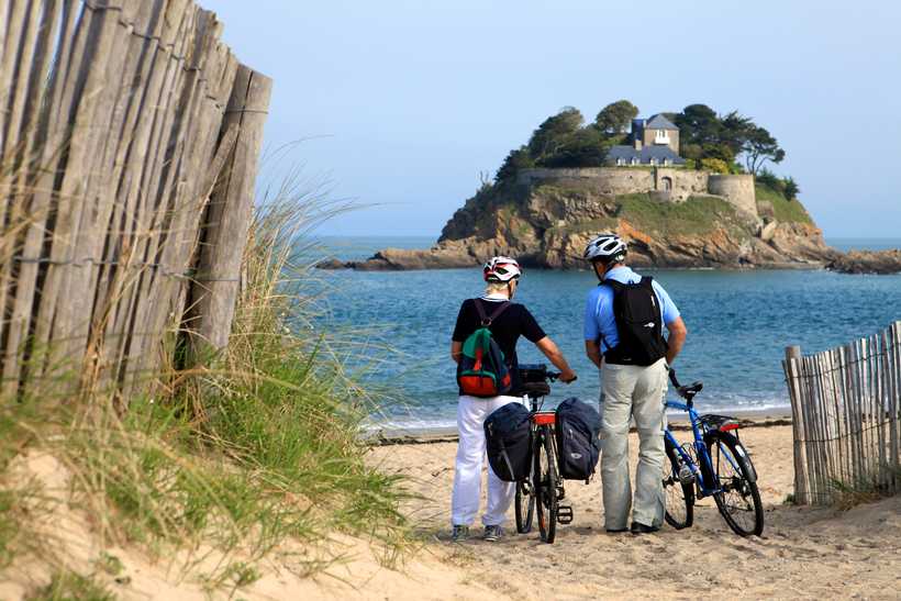 Cyclistes face à la mer sur la côte d'Emeraude en Bretagne